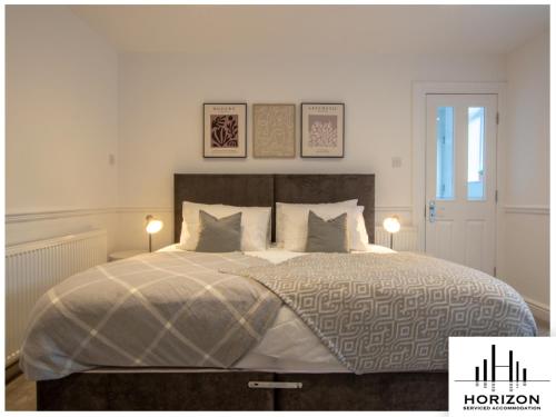 a bedroom with a large bed with two lamps at Bright & Spacious Central Apartment in Harrogate