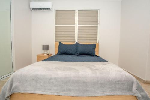 1 dormitorio con 1 cama grande con almohadas azules en EcoMar Rentals 3/2: Cabo Rojo PR: Piscina y Playas, en Cabo Rojo