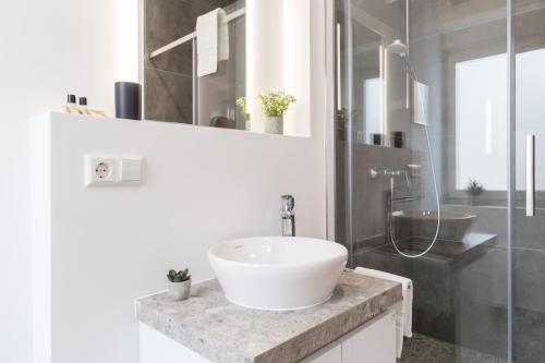 a white bathroom with a sink and a shower at living TIMELESS - Adler Apartments Sasbachwalden in Sasbachwalden