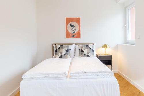 a white bed in a white room with at living TIMELESS - Adler Apartments Sasbachwalden in Sasbachwalden