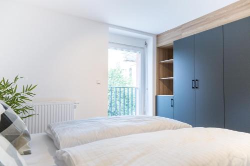a bedroom with two beds and a blue cabinet at living TIMELESS - Adler Apartments Sasbachwalden in Sasbachwalden