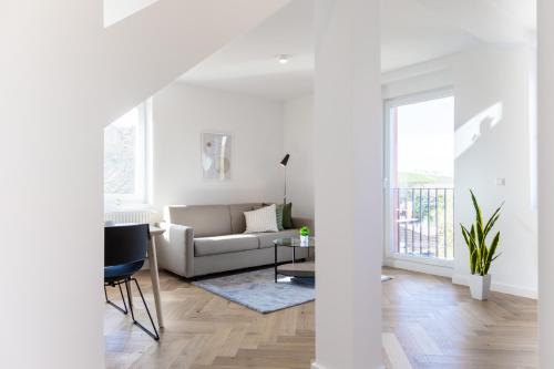 a white living room with a couch and a table at living TIMELESS - Adler Apartments Sasbachwalden in Sasbachwalden