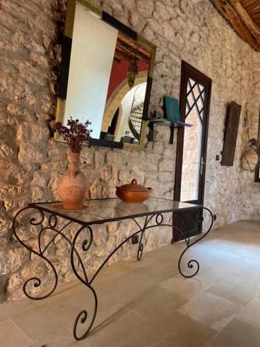 a table with a mirror and a vase on it at Dar Volubilis spacieuse villa avec piscine, 5 chambres vue sur forêt in Essaouira