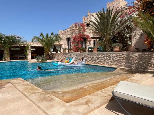a group of people playing in a swimming pool at Dar Volubilis spacieuse villa avec piscine, 5 chambres vue sur forêt in Essaouira