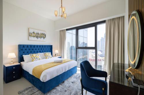 a bedroom with a blue bed and a large window at Luxury 2-BR Apt with Burj View in Dubai
