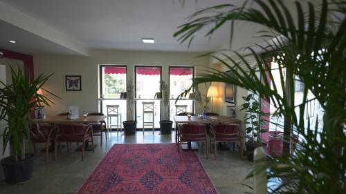 a dining room with tables and chairs and a rug at Pertevniyal Aziziye Hotel in Konya