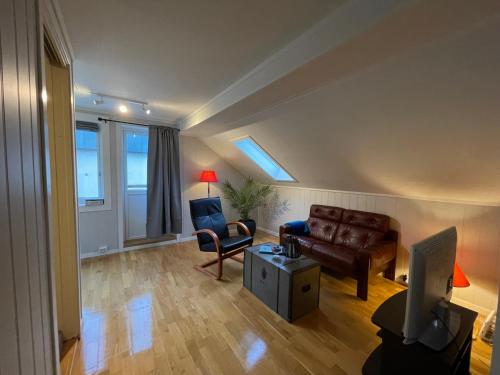 a living room with a couch and a chair at Bakkebo Rampestreken in Åndalsnes