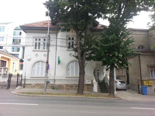 a white house with two trees in front of it at Hostel Andrei in Iaşi