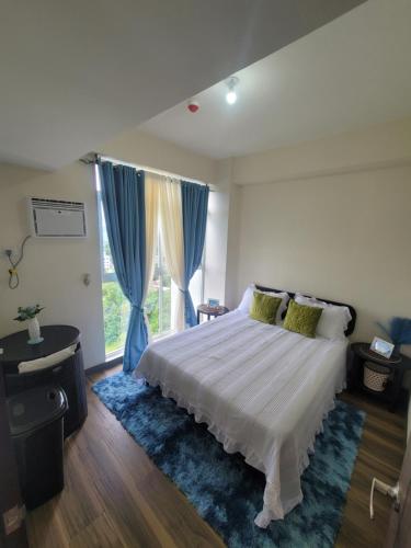a bedroom with a bed and a large window at Newcoast Boracay Top Floor View in Boracay