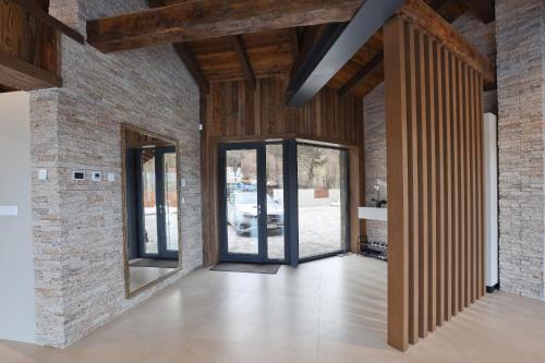 un couloir ouvert avec des murs en briques et des portes en verre dans l'établissement Chalet Bohemian, à Zázrivá