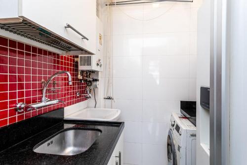 - une petite cuisine avec un évier et du carrelage rouge dans l'établissement Flamengo Soul - 4 Hóspedes, Privacidade e Conforto, à Rio de Janeiro