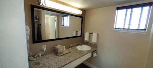 baño con lavabo y espejo grande en Econo Lodge Sacramento Convention Center, en Sacramento