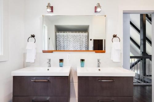 een badkamer met 2 wastafels en een spiegel bij Stunning waterfront getaway w hot tub sleeps 14 in Sainte-Cécile-de-Masham