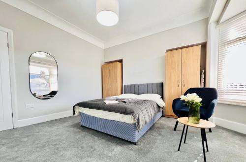1 dormitorio con cama, silla y espejo en The Stunning house welcomes you en Liverpool