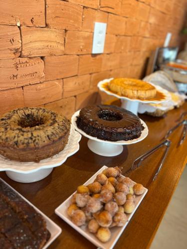 a table topped with different types of cakes and pastries at Paraíso Capitólio Suítes Pousada in Capitólio