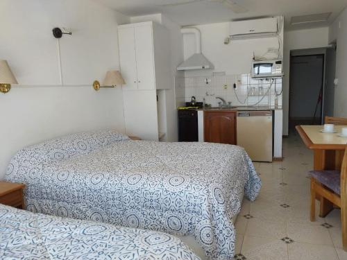 a small bedroom with a bed and a kitchen at Mirador Azul Apart, 3 A,B,C in Las Grutas