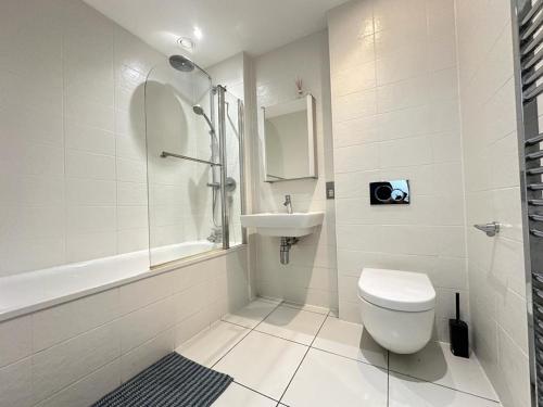 uma casa de banho branca com um WC e um lavatório em Luxury 2 Bedroom Penthouse Near Central London em Londres