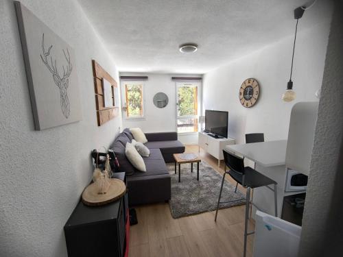 ein Wohnzimmer mit einem Sofa und einem Tisch in der Unterkunft STUDIO COSY ISARD P2000 in Bolquere