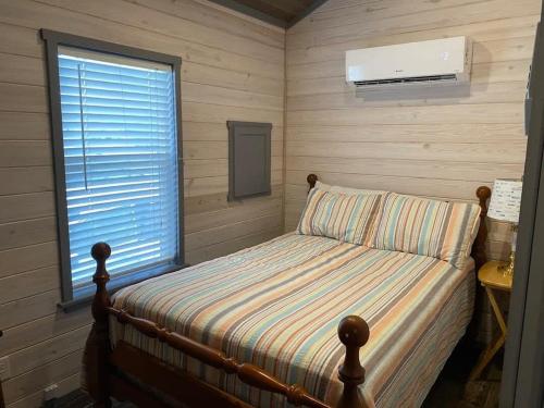 um pequeno quarto com uma cama e uma janela em Surf City 2BR Park Home with Waterfront View and Parking em Surf City