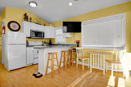 a kitchen with white appliances and a table and chairs at Surf City 2BR Model Home with Pool and Boat Ramp Access in Surf City