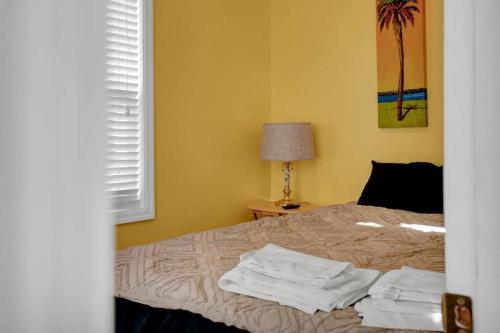 a bedroom with a bed with towels on it at Surf City 2BR Model Home with Pool and Boat Ramp Access in Surf City