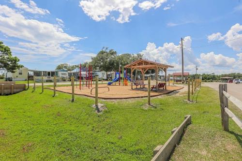a playground in a park with a play area at Surf City 2BR Model Home with Pool and Boat Ramp Access in Surf City