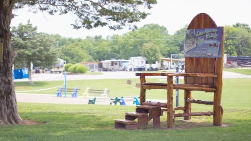a park with a wooden bench and a tree at Rustic Cabin with Pool Access in Bloomington