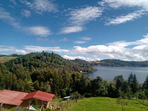 a view of a lake from a hill with a house at Finca Refugio Guanumen in Tota