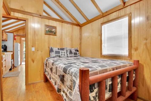 a bedroom with a bed in a room with a window at Charming Log Cabin in Bloomington in Bloomington