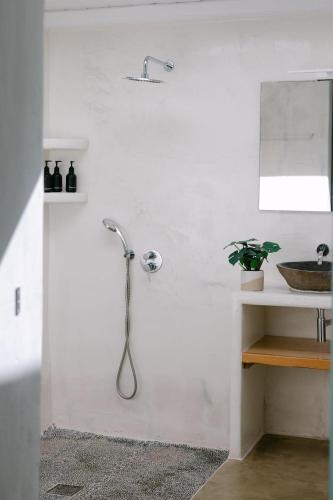 a white bathroom with a shower and a sink at Villa Blue Zircon in Stelida