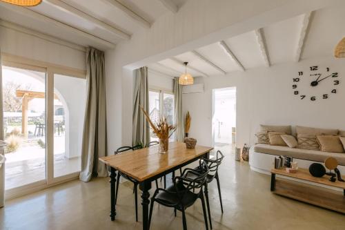 a dining room with a table and a clock on the wall at Villa Blue Zircon in Stelida