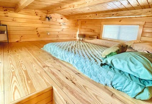 a large bed in a log cabin bedroom at Charming Cabin near Ark Encounter with Loft in Dry Ridge