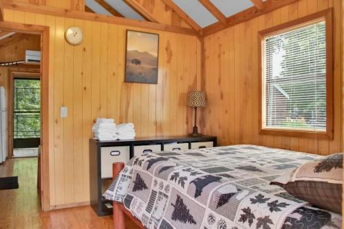 a bedroom with a bed in a wooden room at Homey Cabin in Bloomington with Views in Bloomington