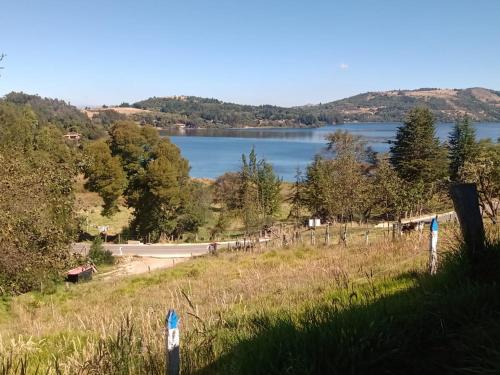 a view of a lake from a hill with a road at Finca Refugio Guanumen in Tota