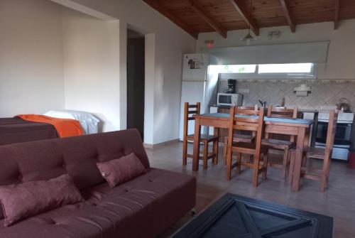 a living room with a couch and a table and chairs at Acceso Viejo Casas de Campo in La Cumbre