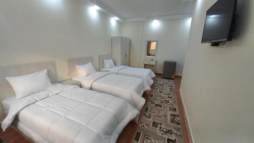 ein Hotelzimmer mit 2 Betten und einem Flachbild-TV in der Unterkunft The Heaven Pyramids in Kairo