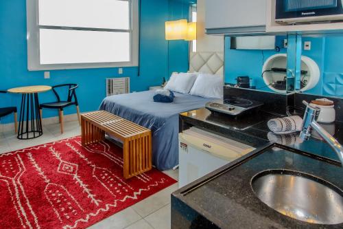 uma casa de banho com uma cama e uma cozinha com um lavatório em Estúdio frente mar de Copacabana WIFI 500M no Rio de Janeiro