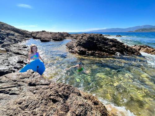 a woman and a man in the water in the ocean at Résidence Padovani Marina in Calcatoggio
