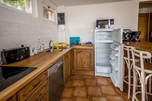 une cuisine avec un réfrigérateur blanc et un évier dans l'établissement Proche Paris vue tour Eiffel (120m2), à Suresnes