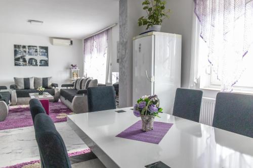 Apartman Albijanić في Sremska Kamenica: طاولة بيضاء عليها إناء من الزهور