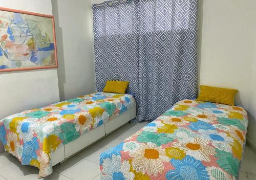 two beds sitting next to each other in a room at Lagunasol in Porlamar