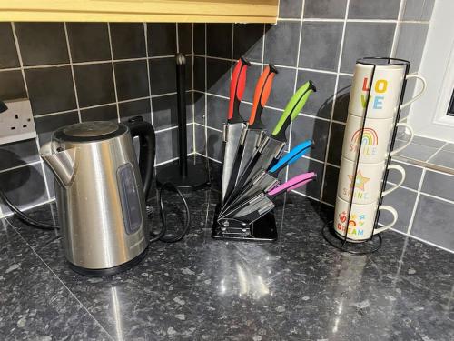 a kitchen counter with a coffee pot and utensils at Walnut Apartment Larne in Larne