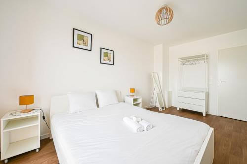 Un dormitorio blanco con una cama blanca y una ventana en Magnifique Appart Tram Parking 4pers, en Pierrefitte-sur-Seine