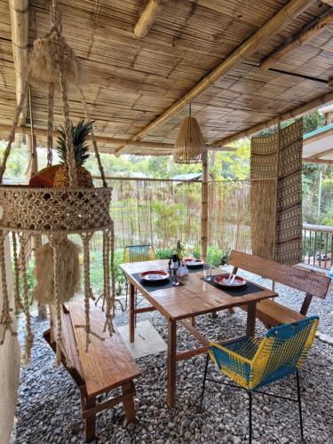 a patio with a wooden table and chairs at Atalaya del Mar Palomino in Palomino