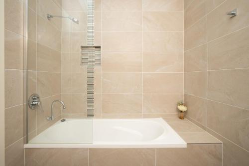 a bathroom with a shower with a bath tub at Generous 2-Bed Townhouse With A Private Balcony in Batemans Bay