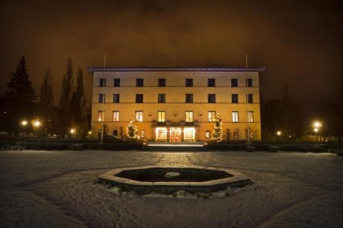 a building with a fountain in front of it at night at Bofors Hotel in Karlskoga