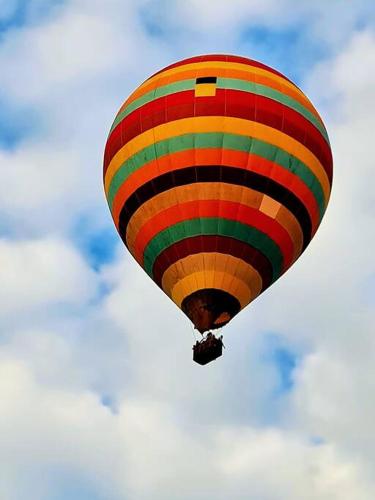a colorful hot air balloon flying in the sky at Chácara em Boituva com piscina e churrasqueira in Boituva
