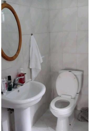 a bathroom with a toilet and a sink and a mirror at Casa dos Amigos in Calheta de São Miguel