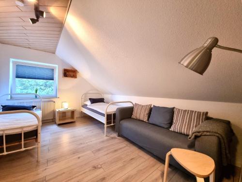 sala de estar con sofá y cama en Ferienwohnung-Wipperau-I, en Uelzen
