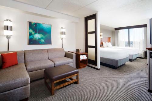 a hotel room with a couch and a bed at Hyatt Place Dallas/Plano in Plano
